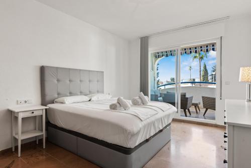 een witte slaapkamer met een groot bed en een balkon bij Marysol beachclose apartment with pool Ref 200 in Benalmádena
