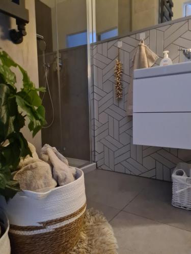a bathroom with a sink and a shower with towels at Posnania Comfort Apartment, free parking, self check-in 24h in Poznań