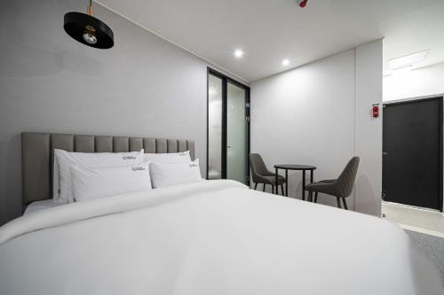 a bedroom with a bed and a table and chairs at Hotel Haeseong in Changwon