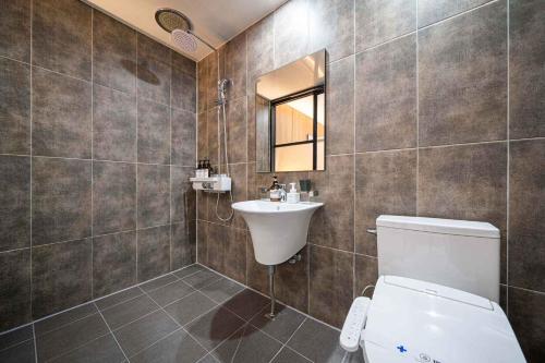 a bathroom with a toilet and a sink and a mirror at Hotel Haeseong in Changwon