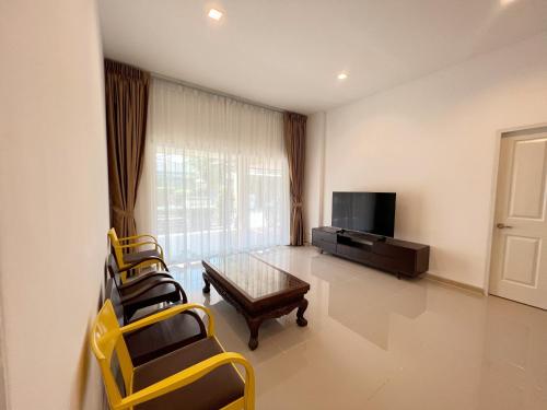 a living room with a table and chairs and a television at Private house Casa seaside Rayong in Ban Chak Phai