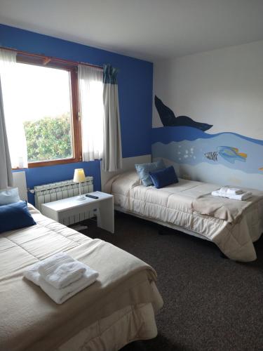 - une chambre avec 2 lits et une fresque murale représentant les dauphins dans l'établissement ROCAYAS HOME, à Esquel