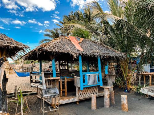 a hut on the beach with palm trees at Half Moon Village and Beach House powered by Cocotel in Campo