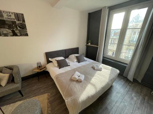 um quarto com uma cama com toalhas em Timus YourHostHelper em Caen