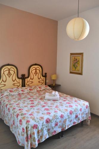 a bedroom with a bed with a floral bedspread at Casa di Osio - Porta Romana in Siena