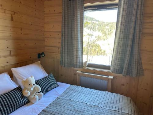 een teddybeer op een bed in een slaapkamer bij Megève Rochebrune, superbe appartement avec jardin in Megève