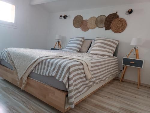 een slaapkamer met een bed met gestreepte dekens en kussens bij Boost Your Immo Six Fours Les Plages Le Rouveau 875 in Six-Fours-les-Plages