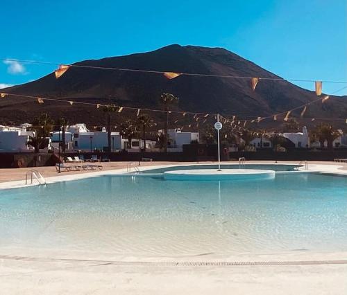 a large swimming pool with a mountain in the background at Villa Maranvi in Playa Blanca