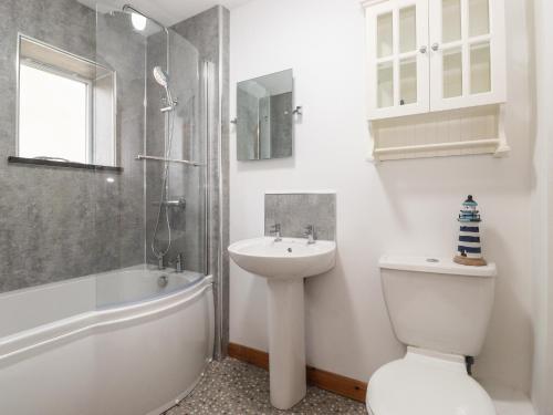 a bathroom with a sink and a toilet and a shower at Coastal Nest 30 Union Street in Seahouses