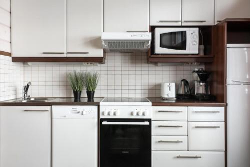 a kitchen with white cabinets and a black oven at Himos Mökki superior - Chalet Cottage superior ski-in-ski-out in Jämsä