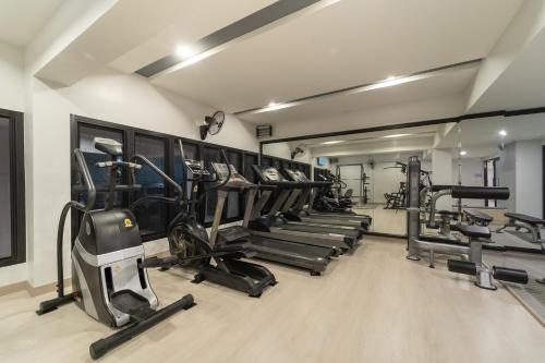 a gym with a row of treadmills and machines at The Space Hotel Lampang in Lampang