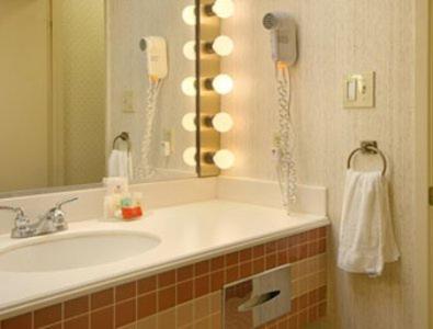 ein Badezimmer mit einem Waschbecken und einem Telefon an der Wand in der Unterkunft Merced Inn & Suites in Merced