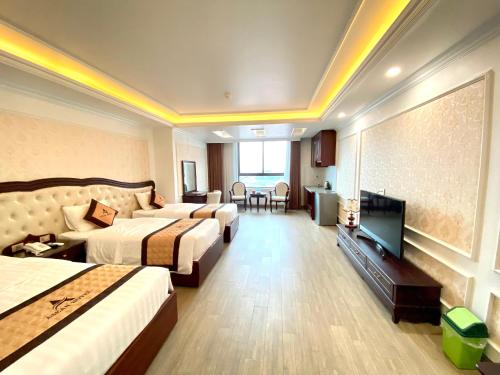 a hotel room with two beds and a flat screen tv at Asean Hotel in Hải Dương