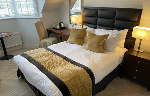 a bedroom with a large bed with a black headboard at Barnett Hill Hotel in Guildford