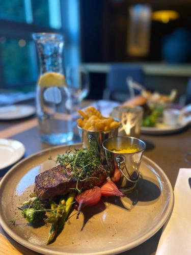 a plate of food with steak and fries on a table at Quality Hotel Sarpsborg in Sarpsborg
