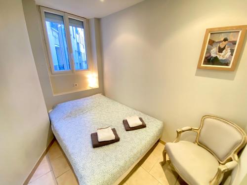 ein kleines Zimmer mit einer Bank und einem Stuhl in der Unterkunft Latour Maubourg By SCLS Locations in Cannes