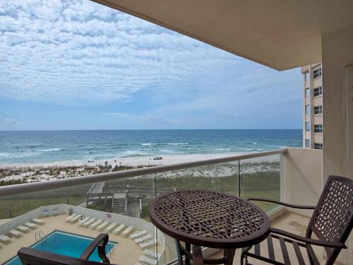 a balcony with a table and chairs and the beach at Regency Towers #501 West in Pensacola Beach