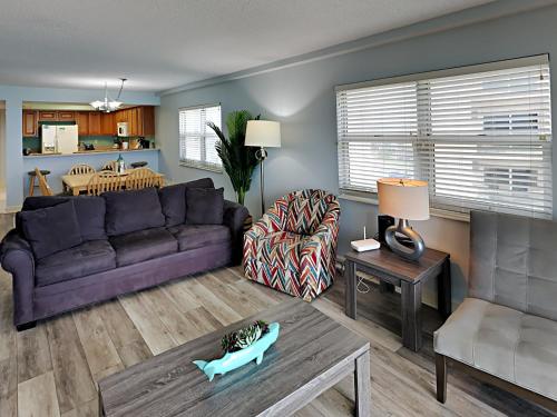 a living room with a purple couch and a table at Regency Towers #501 West in Pensacola Beach
