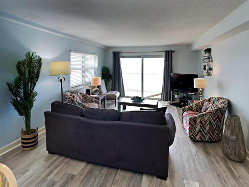 a living room with a black couch and chairs at Regency Towers #501 West in Pensacola Beach