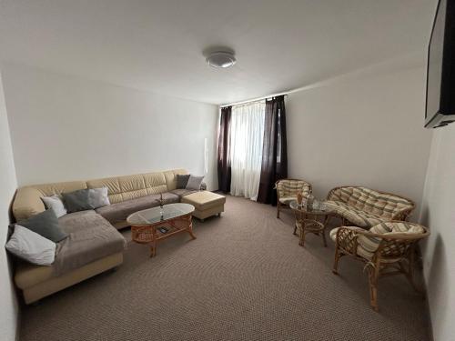 a living room with a couch and a table and chairs at Penzion Tři pumpy in Tři Studně