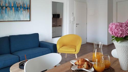 uma sala de estar com um sofá azul e uma mesa com sumo de laranja em Marisa Apartments Hvar II em Hvar