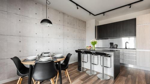 a kitchen and dining room with a table and chairs at Flatbook - City Center Apartments Brabank with Parking in Gdańsk