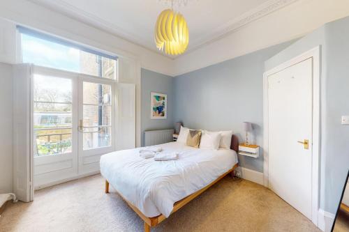 een slaapkamer met een groot bed en een raam bij Charming 1 bedroom apartment in Finsbury Park in Londen