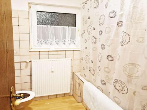 a bathroom with a shower curtain and a sink at Nice Apartments in Gummersbach in Gummersbach