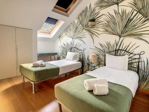 1 Schlafzimmer mit 2 Betten und einem Palmenmilch in der Unterkunft Canto Idílico by LovelyStay in Funchal