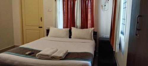 1 dormitorio con 1 cama con 2 toallas en Trinetraa Inc, en Chennai
