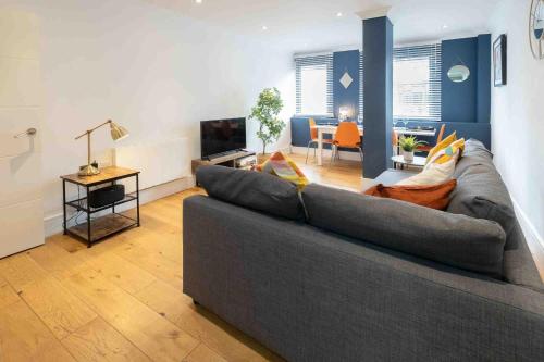 a living room with a gray couch and a television at Riverside House Bristol in Bristol