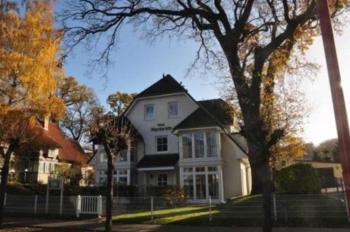 a white house with a tree in front of it at Haus Margarete in Binz