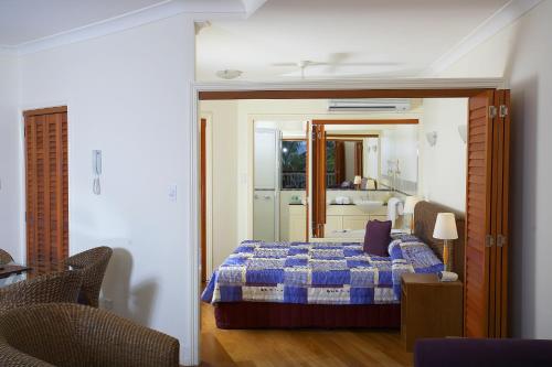 a bedroom with a bed with a blue comforter at Mantra on the Inlet in Port Douglas