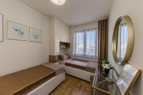 Habitación pequeña con cama y espejo. en Apartment in Kastel Kambelovac with balcony, air conditioning, W-LAN, washing machine 5143-1, en Kaštela