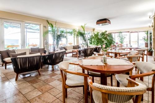 um restaurante com mesas, cadeiras e janelas em Hotel Squash Centrum em Prievidza