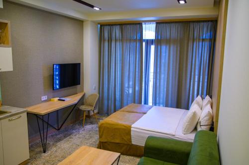 a hotel room with a bed and a desk and a television at Rooftop Apart-Hotel in Yerevan