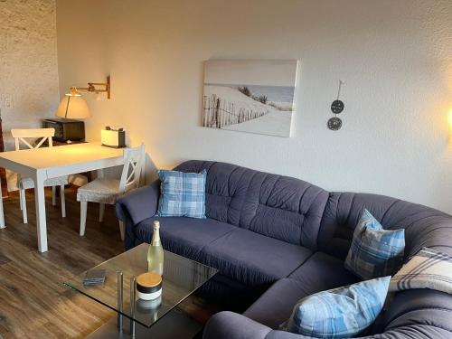 Haus Lith - Fewo Olesen في نوردستراند: غرفة معيشة مع أريكة أرجوانية وطاولة