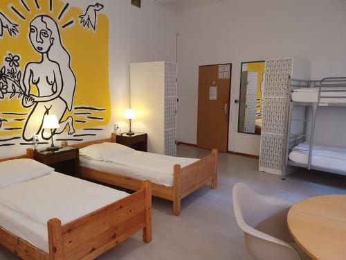 Zimmer mit 3 Betten, Tisch und Stühlen in der Unterkunft Die Fabrik - baxpax Hotel in Berlin