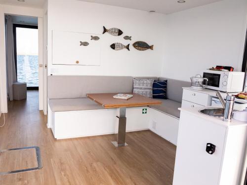 a small kitchen with a table and a microwave at Barco Casa Fuzeta in Fuzeta