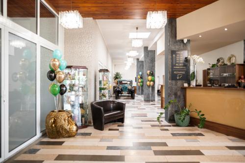 a lobby with a chair and balloons in a store at Hotel Fontána in Brno
