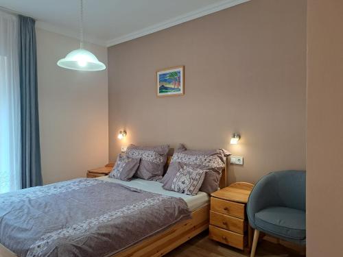- une chambre avec un lit et une chaise bleue dans l'établissement Andrea Villa Hévíz II, à Hévíz