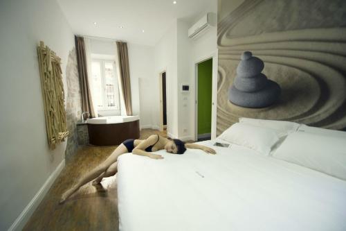 a woman laying on a bed in a bedroom at 7 Inn Spanish Steps in Rome