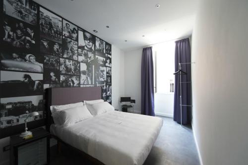 a bedroom with a white bed with pictures on the wall at 7 Inn Spanish Steps in Rome