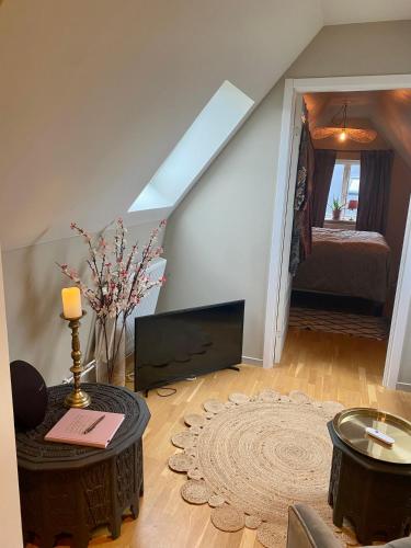 a living room with a tv and a couch at Lomma Station Inn Loft in Lomma