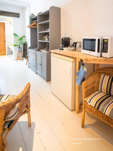 a kitchen with a counter with a microwave and a couch at De Stadsboerderij in Kampen