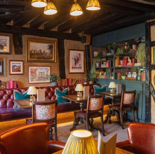 a restaurant with couches and tables and chairs at Salisbury Arms Hotel in Hertford
