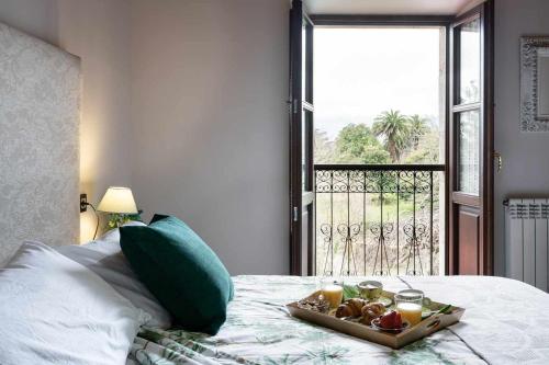 a tray of food on a bed with a window at Casa rural la javariega in Ribadedeva
