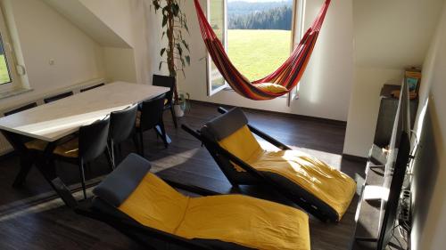Zimmer mit einem Tisch, Stühlen und einer Hängematte in der Unterkunft Apartment with mountain view and rivers close by in Šmartno ob Dreti