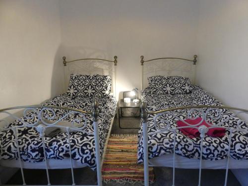 a bedroom with two twin beds and a rug at Rowland House - Central Skipton, Dales Gateway in Skipton