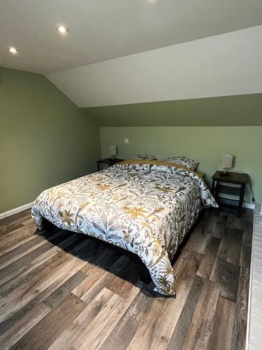 une chambre avec un lit et un parquet dans l'établissement Duplex paisible à la campagne, à Relans